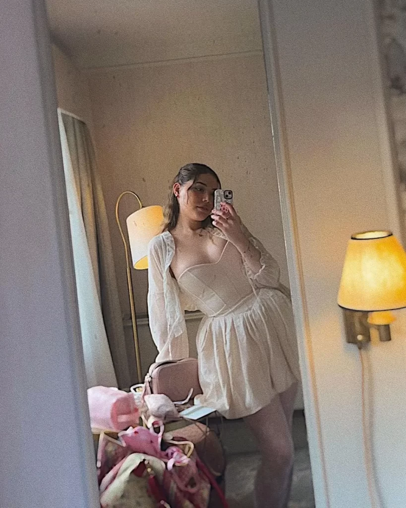 AJ Clementine taking mirror selfie in stylish outfit.