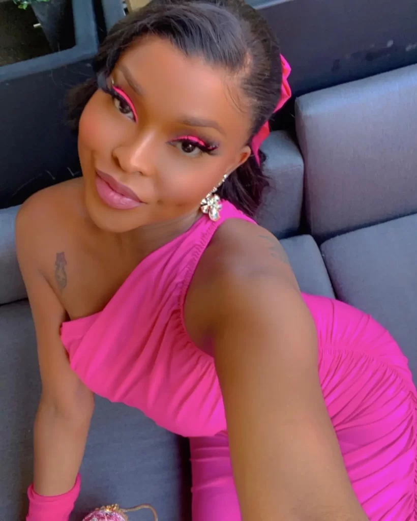 Amiyah Scott in pink dress with vibrant makeup smiling.