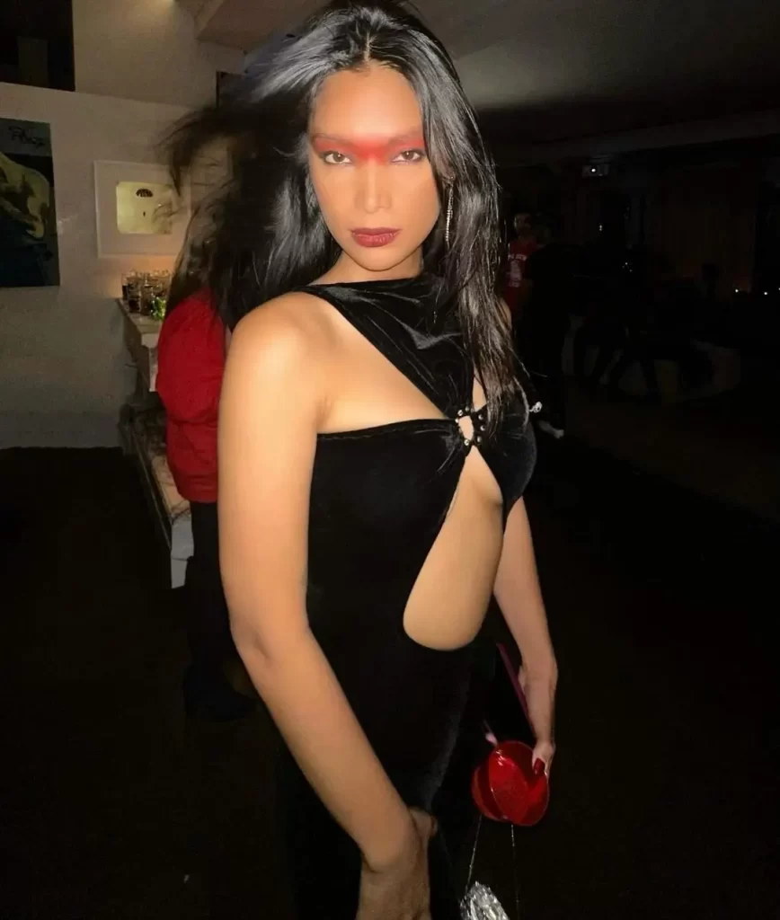 Geena Rocero with bold makeup and stylish outfit at an event.