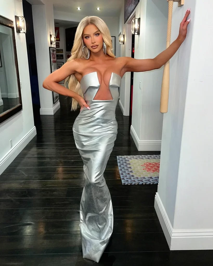 Gigi Gorgeous in glamorous silver dress posing indoors.