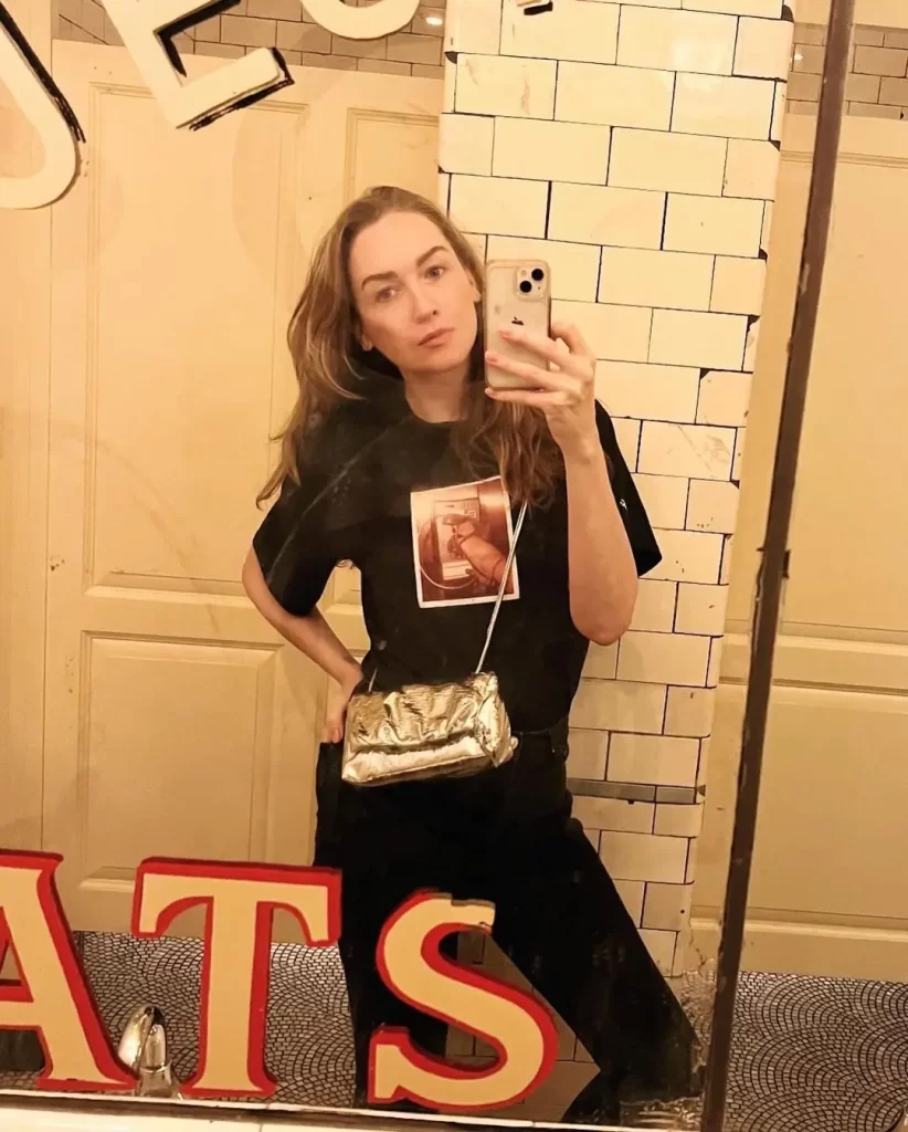 Jamie Clayton taking mirror selfie with phone.