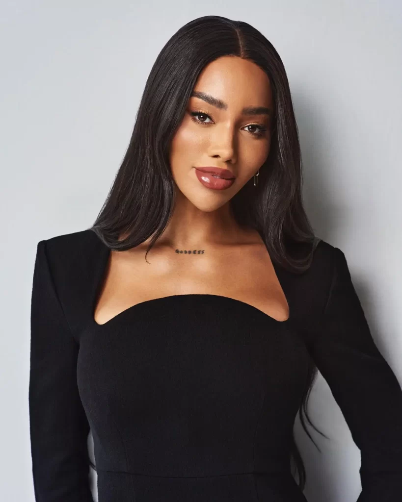 Munroe Bergdorf in elegant black dress posing for portrait.