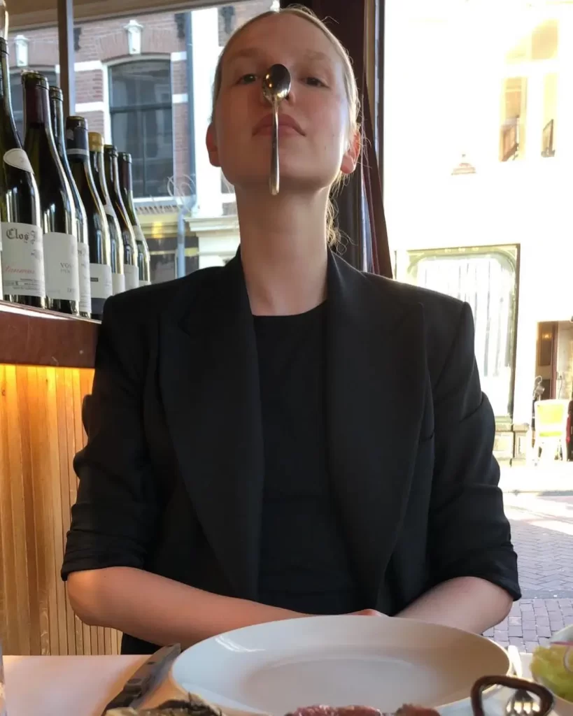 Valentijn De Hingh balancing spoon on nose at restaurant table.