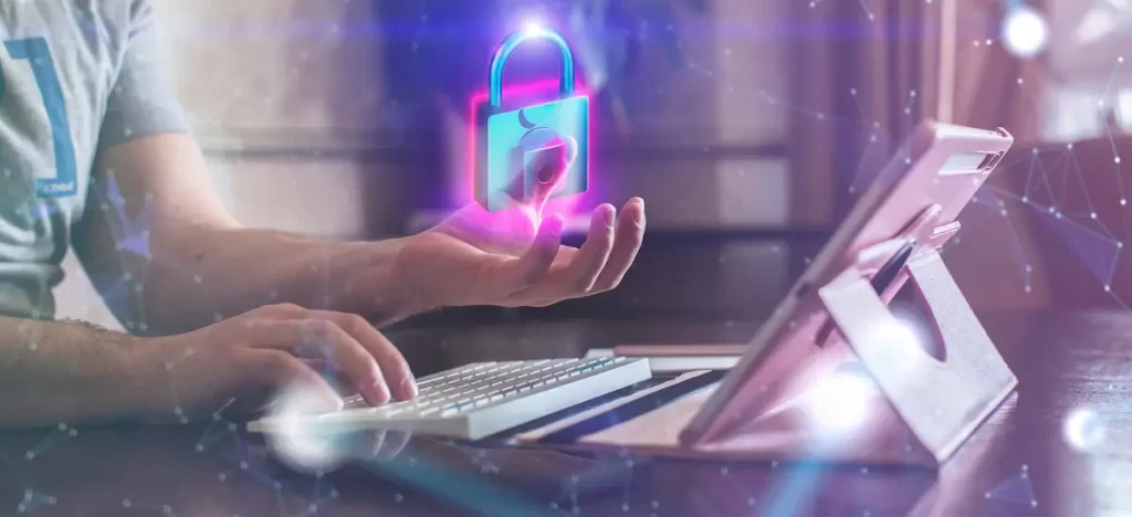 Pessoa com um holograma de cibersegurança sobre um computador portátil.