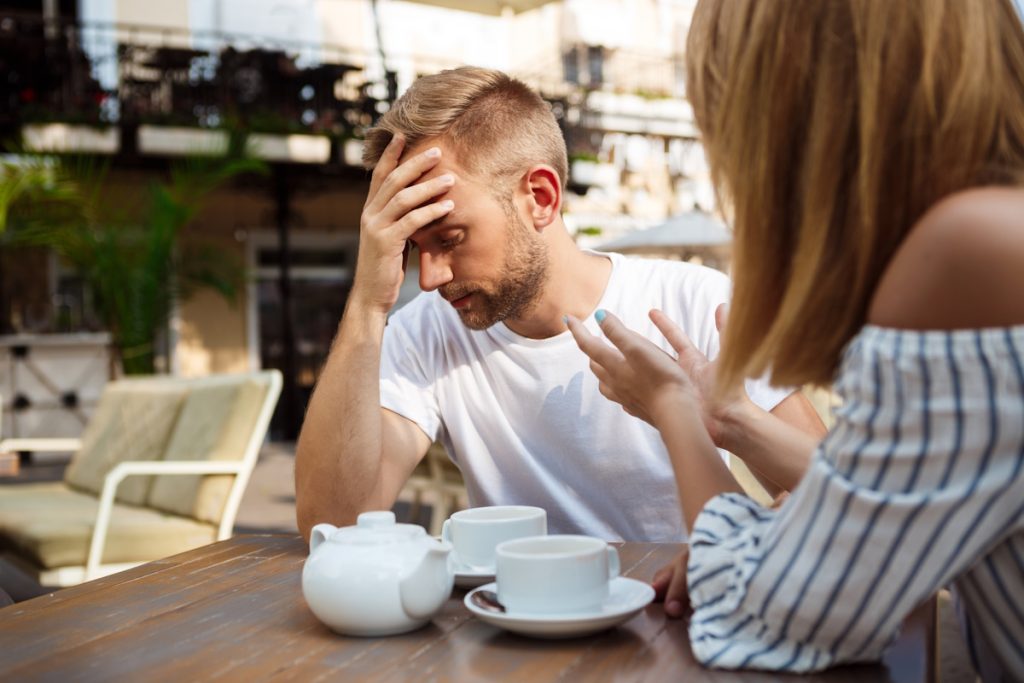 Dating Red Flags To Look Out - Mann gestresst während des Gesprächs im Freien Cafe