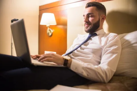 Ein Mann surft mit einem Laptop Sofa