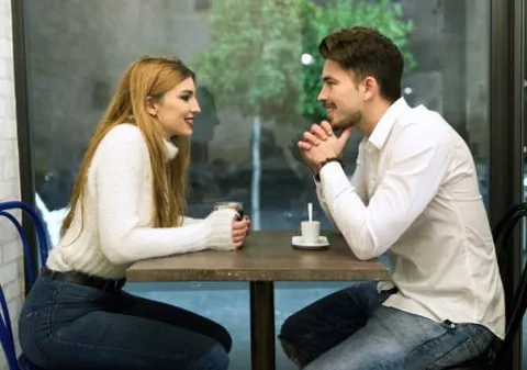 Zwei Personen unterhalten sich an einem Café-Tisch