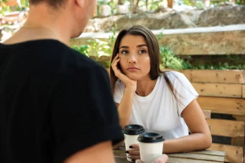 Duas pessoas tendo uma conversa séria em um café